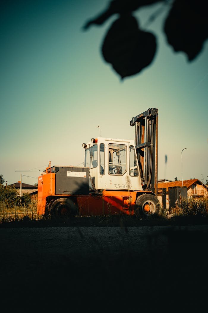 Services A red and white forklift stands in a sunny rural landscape in Doboj, Bosnia.