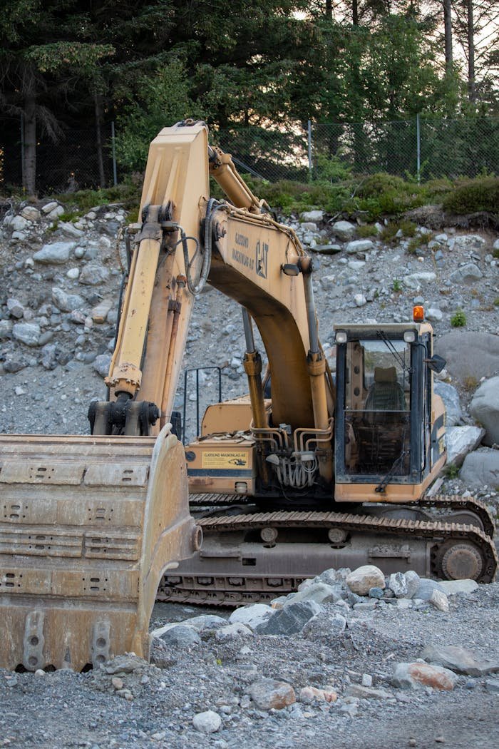 Services Excavator working in a rocky field in Norway, showcasing heavy machinery operation.